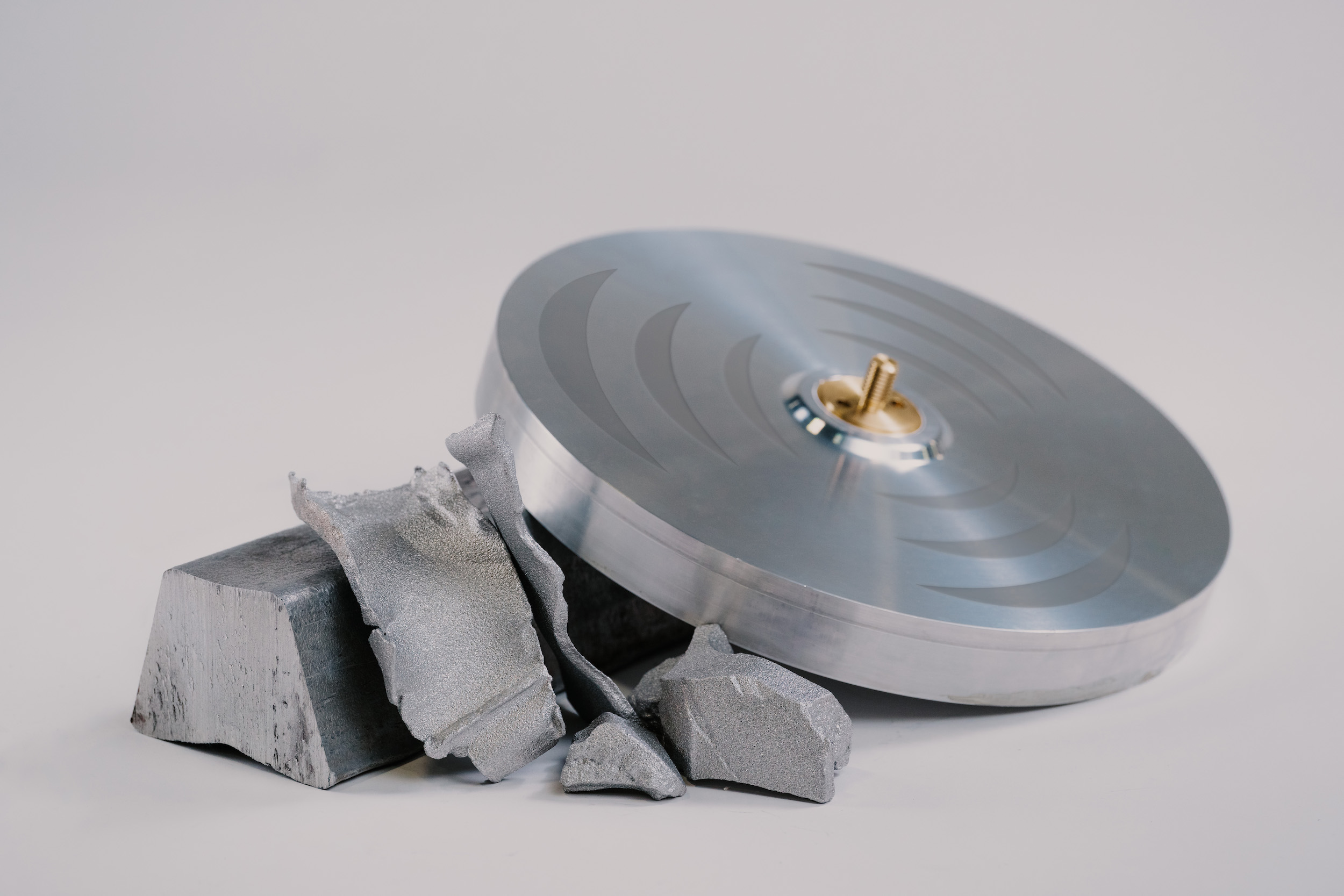 AlumaPower aluminum disc leaning up against chunks of aluminum